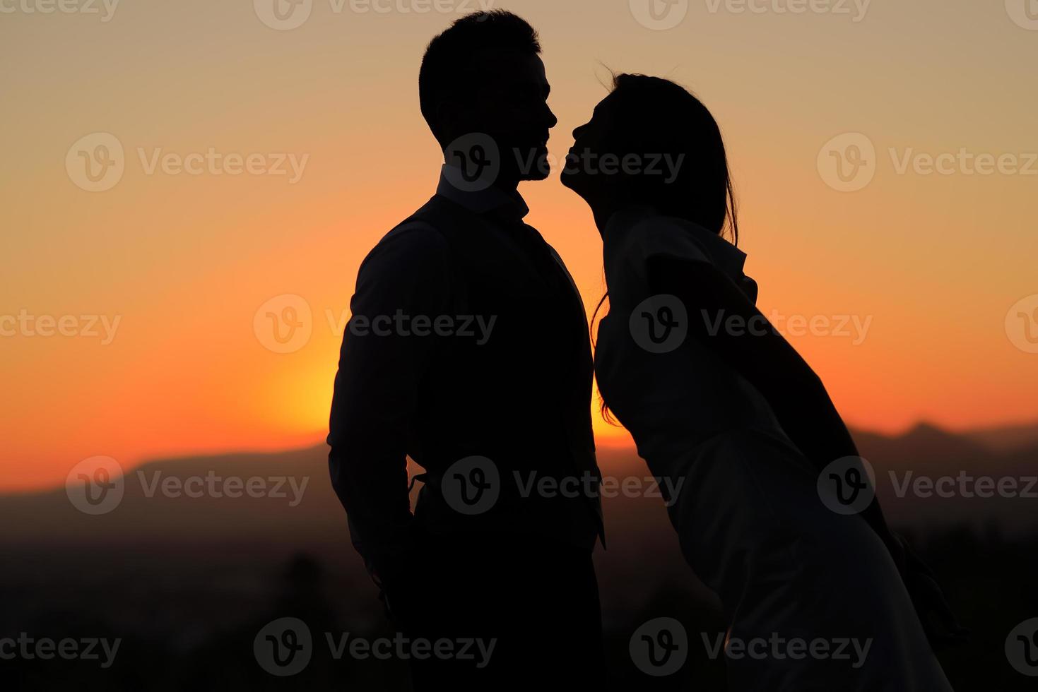 Gerade verheiratetes Paar im Sonnenuntergang foto