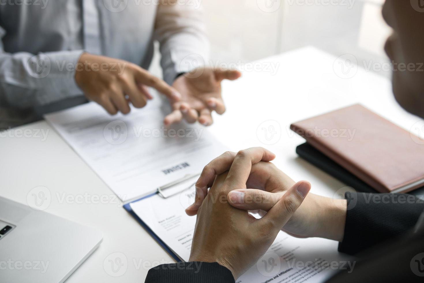 Ein männlicher Mitarbeiter erklärt dem Manager, während er im Büroraum interviewt wird. foto