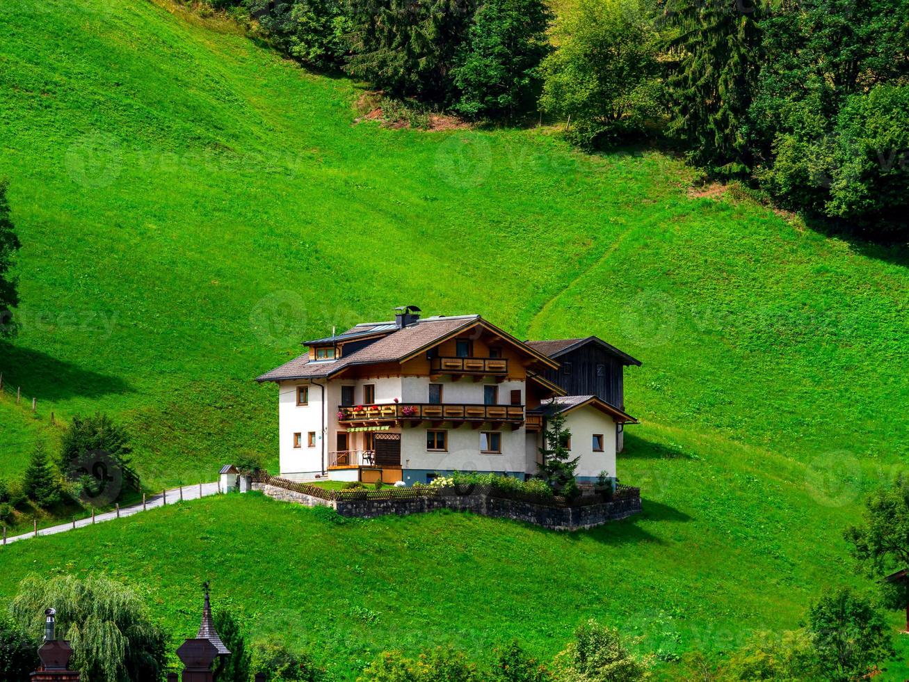 grüne hügel eines alpinen resorts in österreich im sommer. kleines Dorf, Hotels und Chalets, alles in Farben. schöne Terrassen und Sonnenkollektoren auf den Dächern. die Nähe von Zivilisation und Natur pur. foto