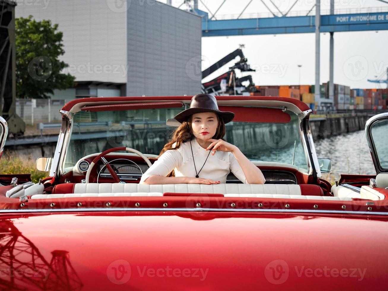 60er Jahre Oldtimer roter Cadillac und ein wunderschönes junges Mädchen foto