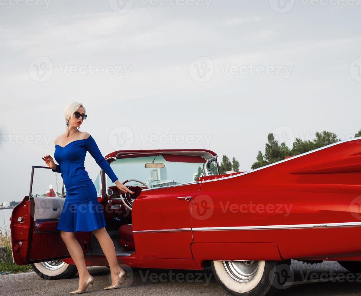 60er Jahre Oldtimer roter Cadillac und ein wunderschönes junges Mädchen foto