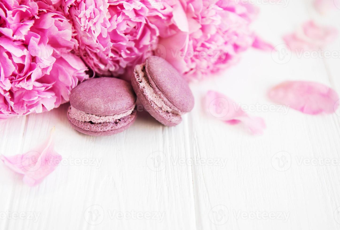 rosa Pfingstrosenblüten mit Macarons foto