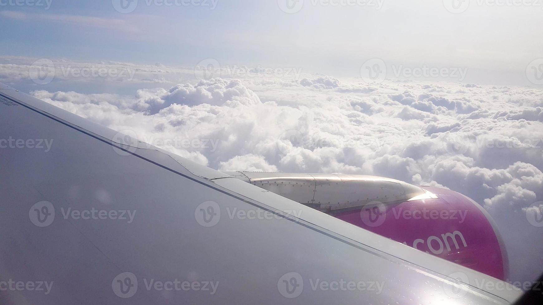 über den Wolken fliegen. Blick vom Passagierfenster des Flugzeugs mit Wolken und Skyline-Horizont. foto