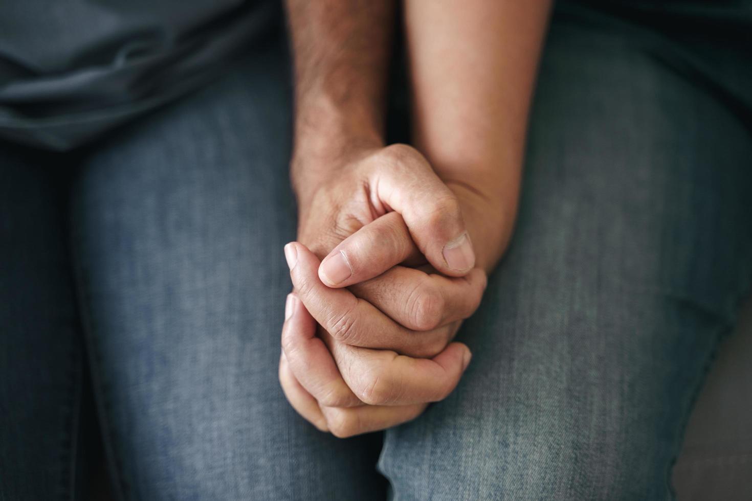 Nahaufnahme eines asiatischen, reifen Paares, das auf der Couch sitzt. frau und ehemann halten sich glücklich und fröhlich an der hand. liebes-, sicherheits- und versicherungsfamilienkonzept foto