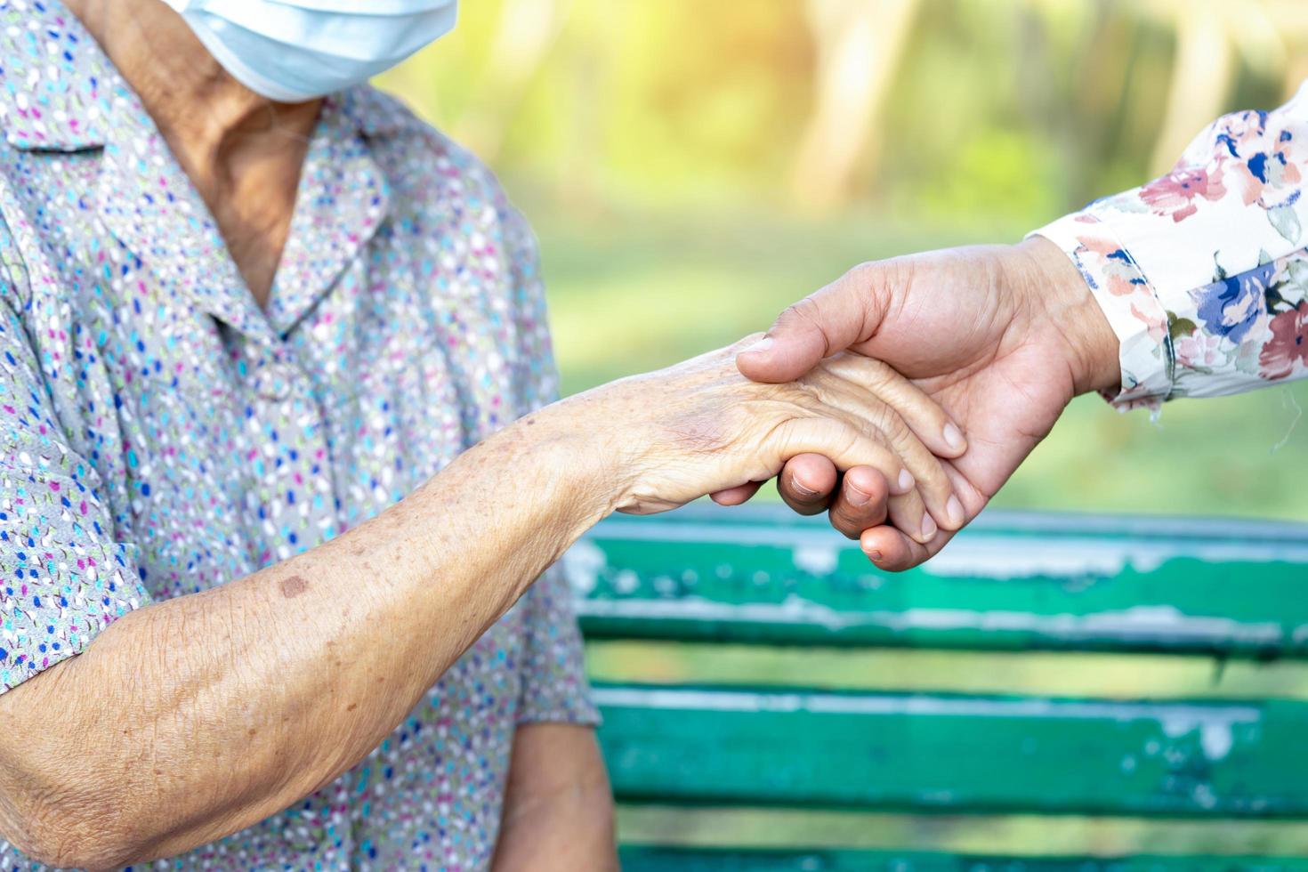 Betreuertochter, die berührende Hände hält asiatische Seniorin oder ältere Patientin der alten Dame mit Liebe, Fürsorge, Hilfe, Ermutigung und Empathie auf der Krankenstation, gesundes, starkes medizinisches Konzept. foto