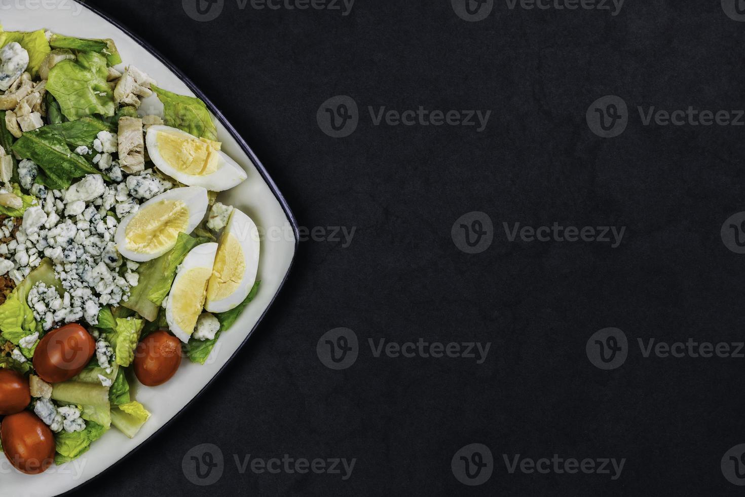 hausgemachter Bio-Salat. sortierter gemüsesalat auf schwarzem hintergrund. foto