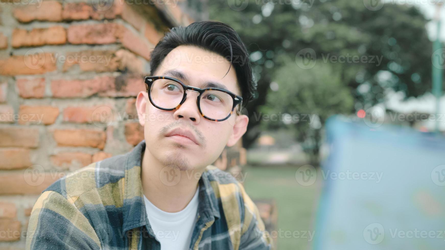 reisender asiatischer mann richtung und blick auf ortskarte während der urlaubsreise in ayutthaya, thailand, rucksacktourist genießen reise in traditioneller stadt. Lifestyle-Männer reisen Konzept. foto