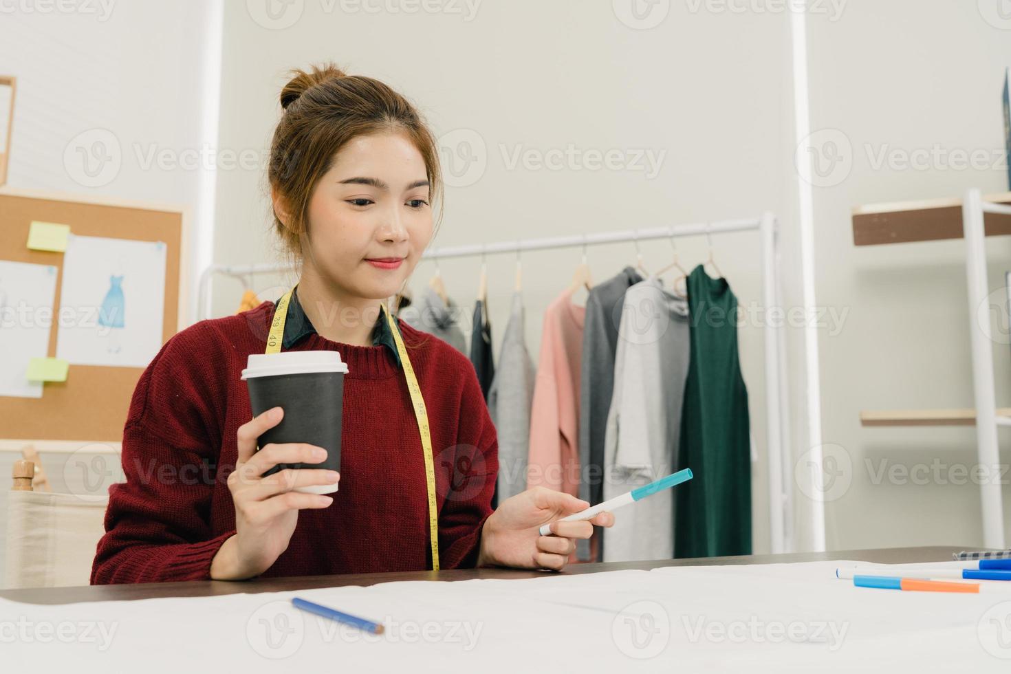 professionelle schöne asiatische modedesignerin, die mit stoffskizzen arbeitet und kleidungsdesign im studio zeichnet. Lifestyle-Frauen-Arbeitskonzept. foto