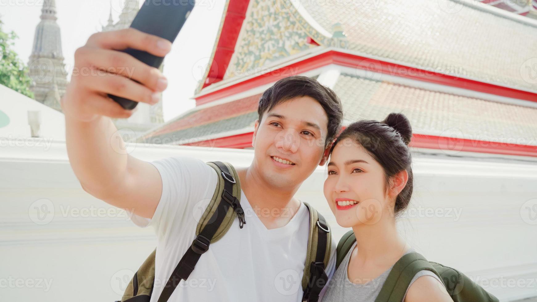asiatisches bloggerpaar reist in bangkok, thailand, süßes paar, das handy selfie fotoansicht verwendet, während es süße zeit in urlaubsreise bei sonnenuntergang verbringt. paar reisen im stadtkonzept. foto