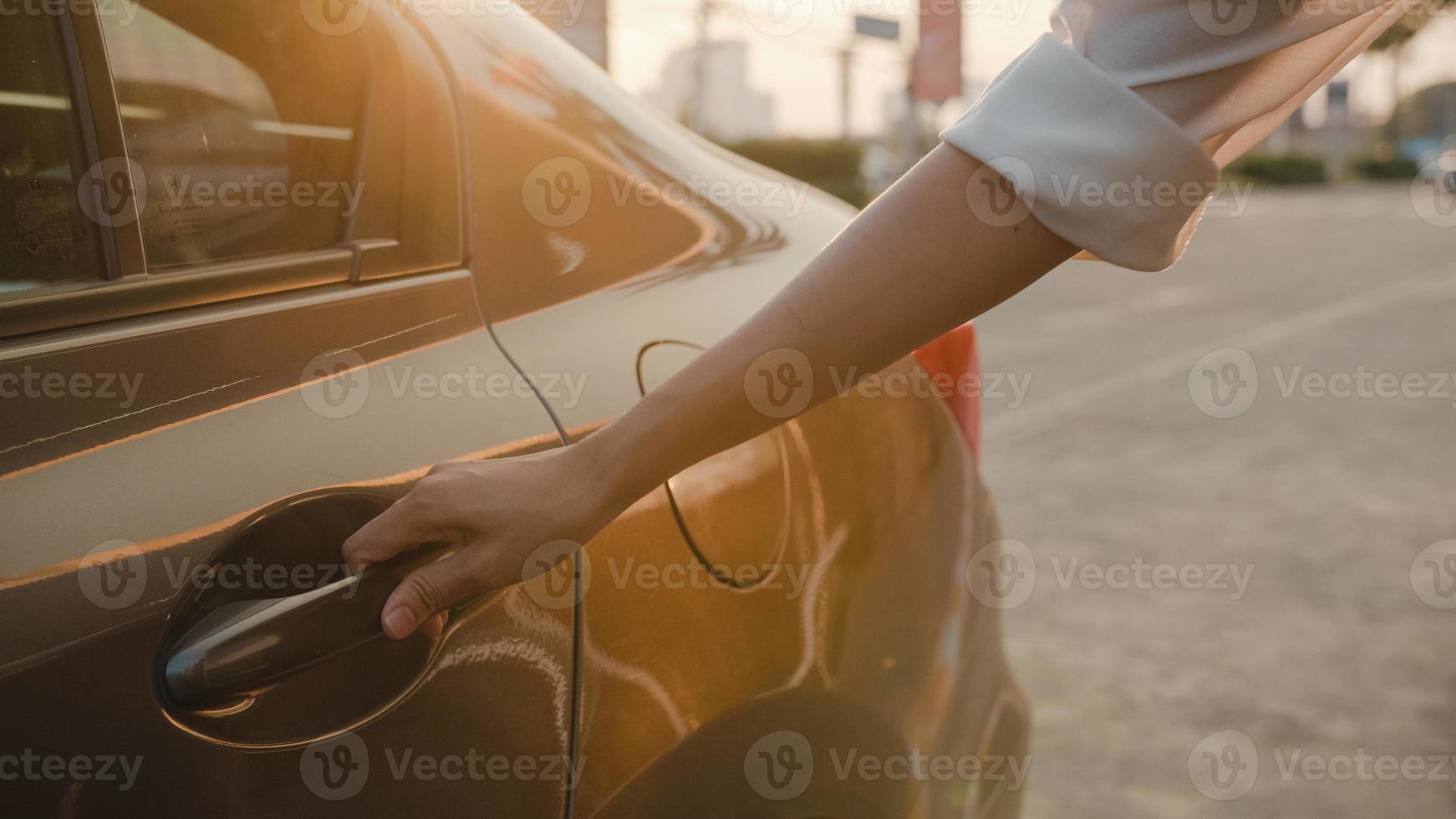 erfolgreiche junge asiatische geschäftsfrau, pendlerin in modischer bürokleidung, die morgens in einer modernen stadt in ein taxi einsteigt oder draußen in ein taxi steigt. business on the go to work-konzept. foto