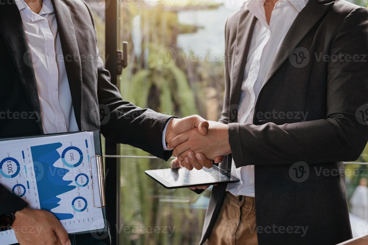 Business-Handshake, der einen Deal mit unscharfem Hintergrund von Menschen abschließt foto