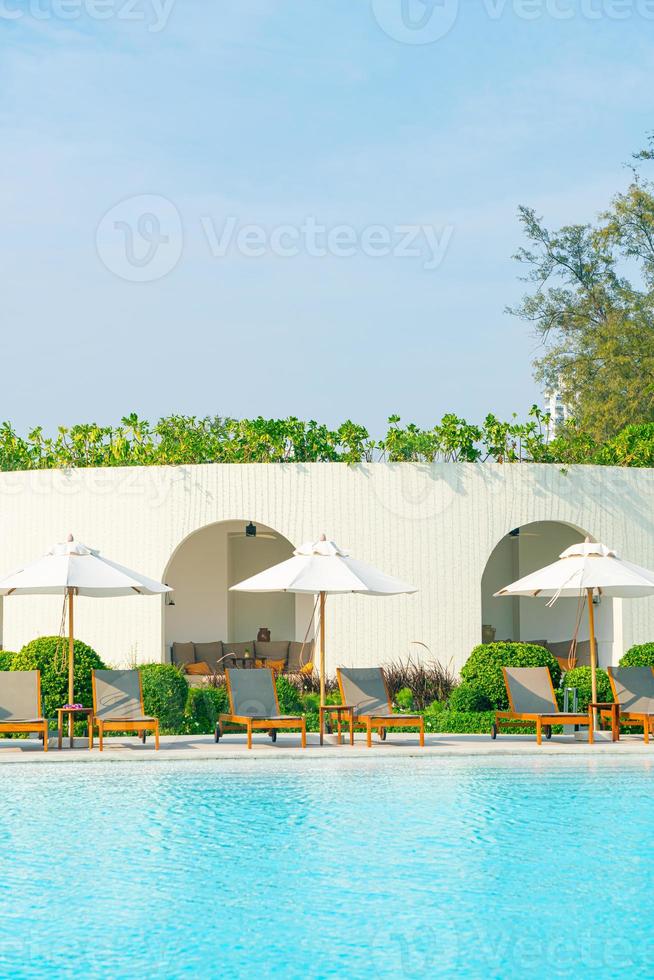 Sonnenschirm mit Bettpool um den Pool mit Ozean-Meer-Hintergrund foto