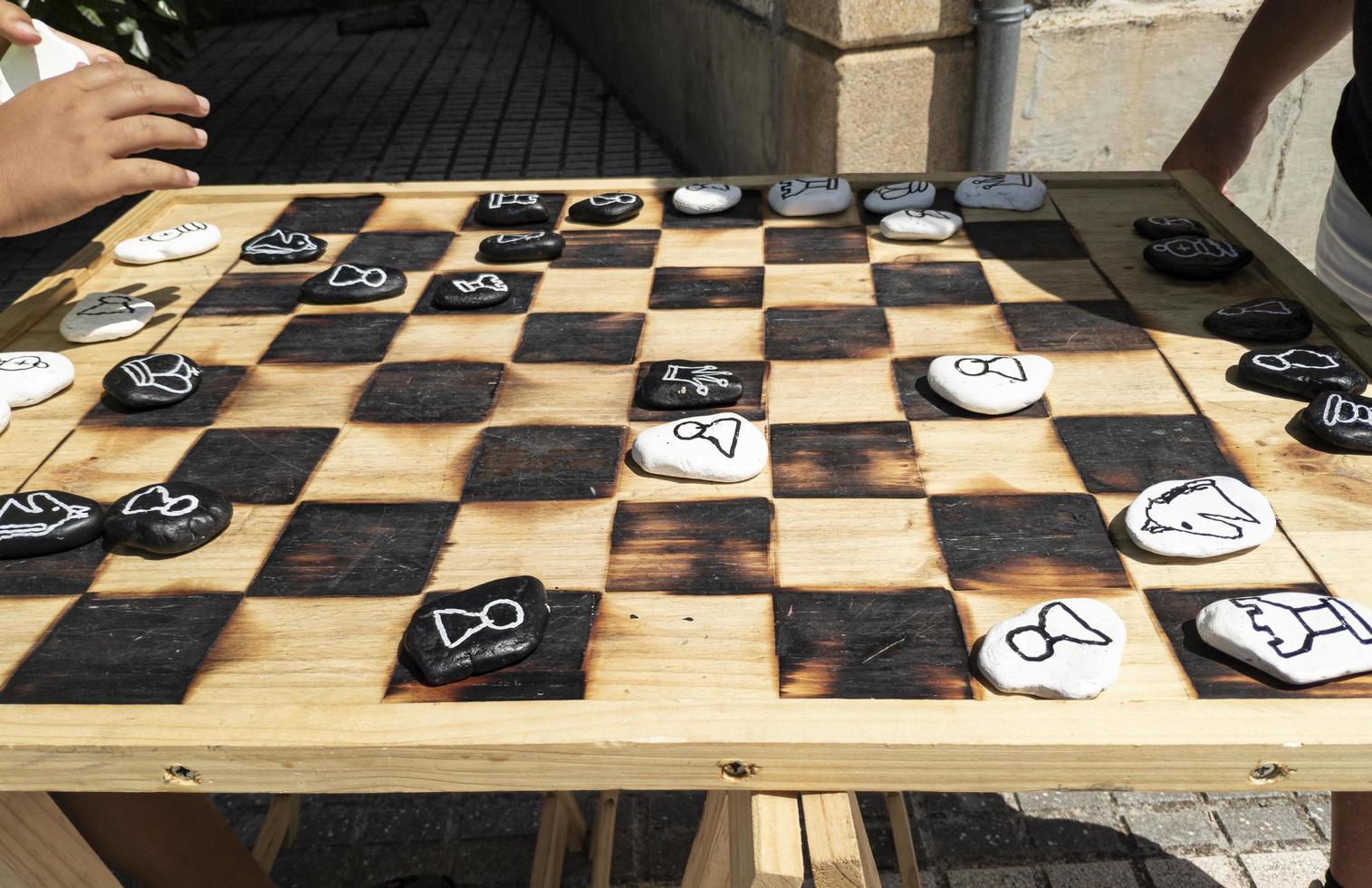 selbstgemachtes Schachspiel aus Holz und Steinen foto
