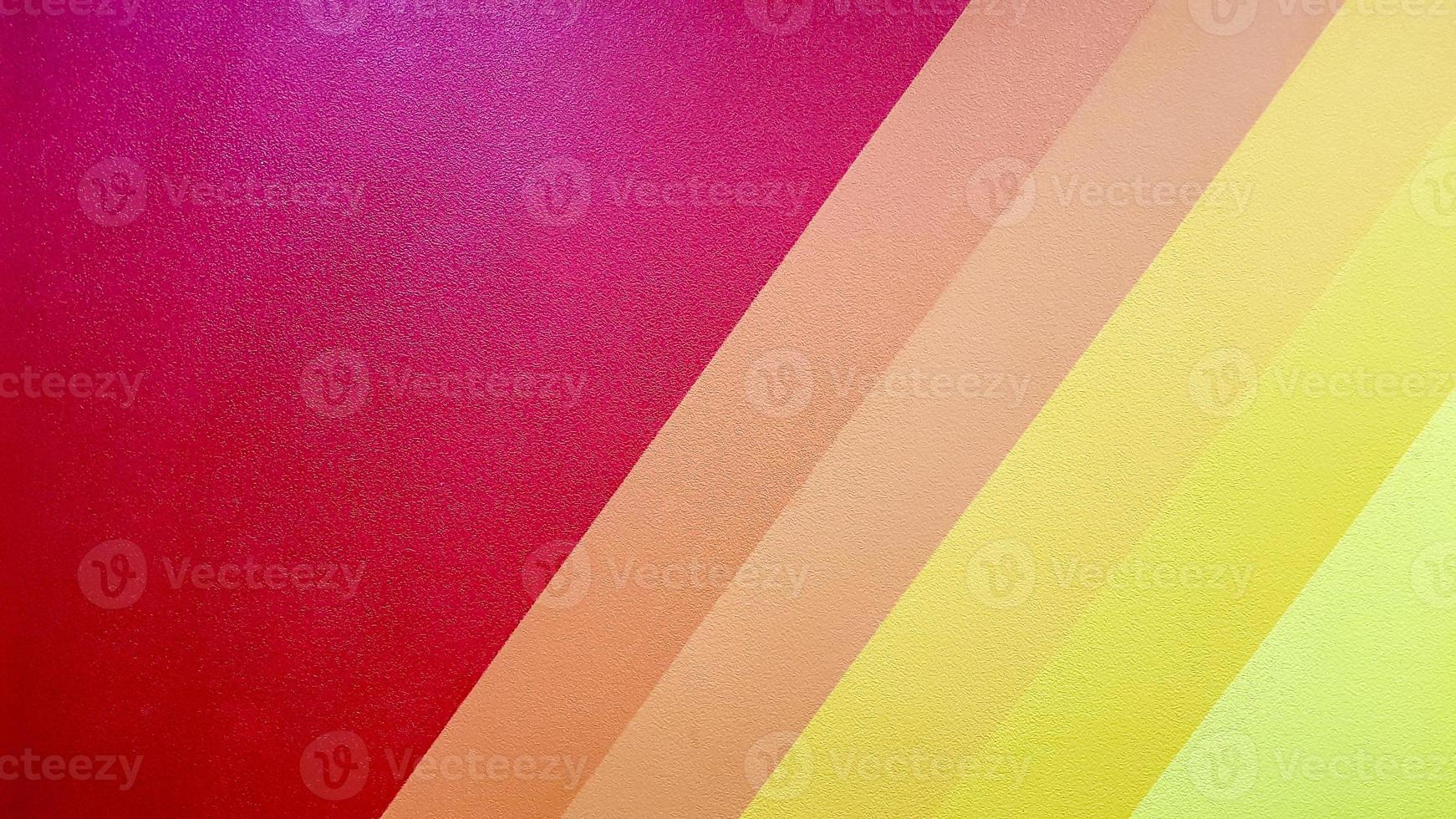 Die Wand ist in rot, rosa, orange, gelb mit diagonalen Linien gestrichen. bunter hintergrund für ihren text und ihre nachricht mit kopierraum. foto