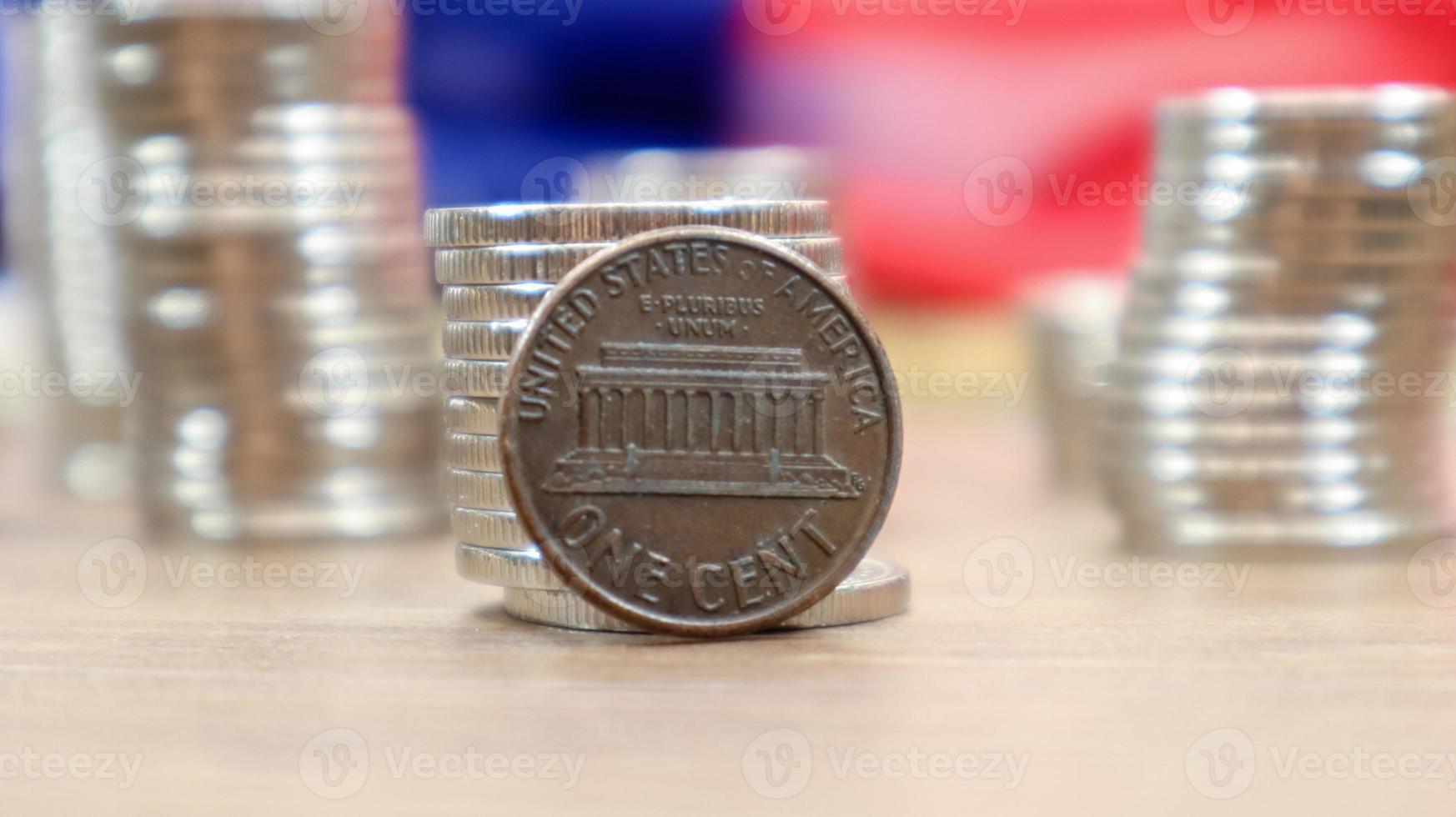 Auf der amerikanischen Flagge liegt eine 1-Cent-Münze des amerikanischen Dollars. die währung ist einen cent über der flagge der vereinigten staaten foto