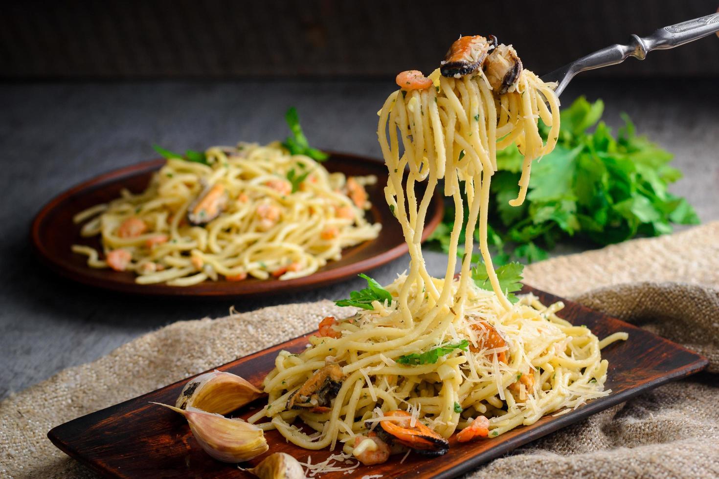 italienische Pasta in cremiger Sauce mit Meeresfrüchten, Garnelen und Muscheln auf einem Teller foto