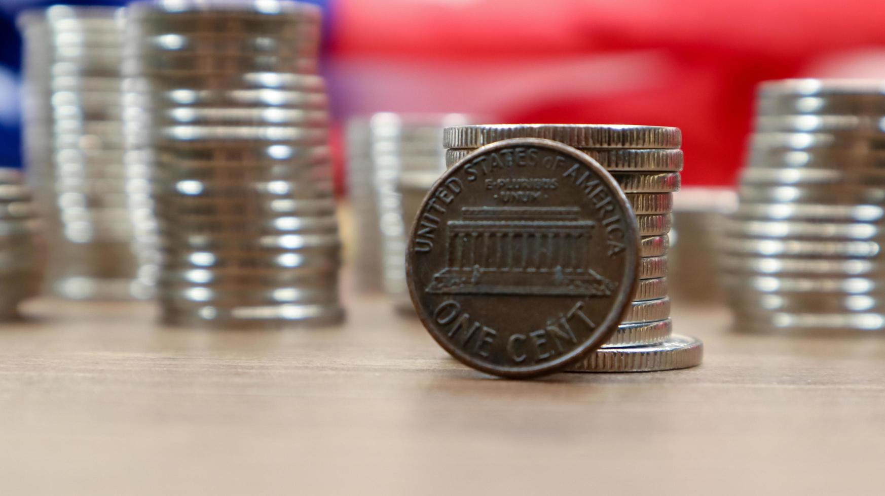 Auf der amerikanischen Flagge liegt eine 1-Cent-Münze des amerikanischen Dollars. die währung ist einen cent über der flagge der vereinigten staaten foto