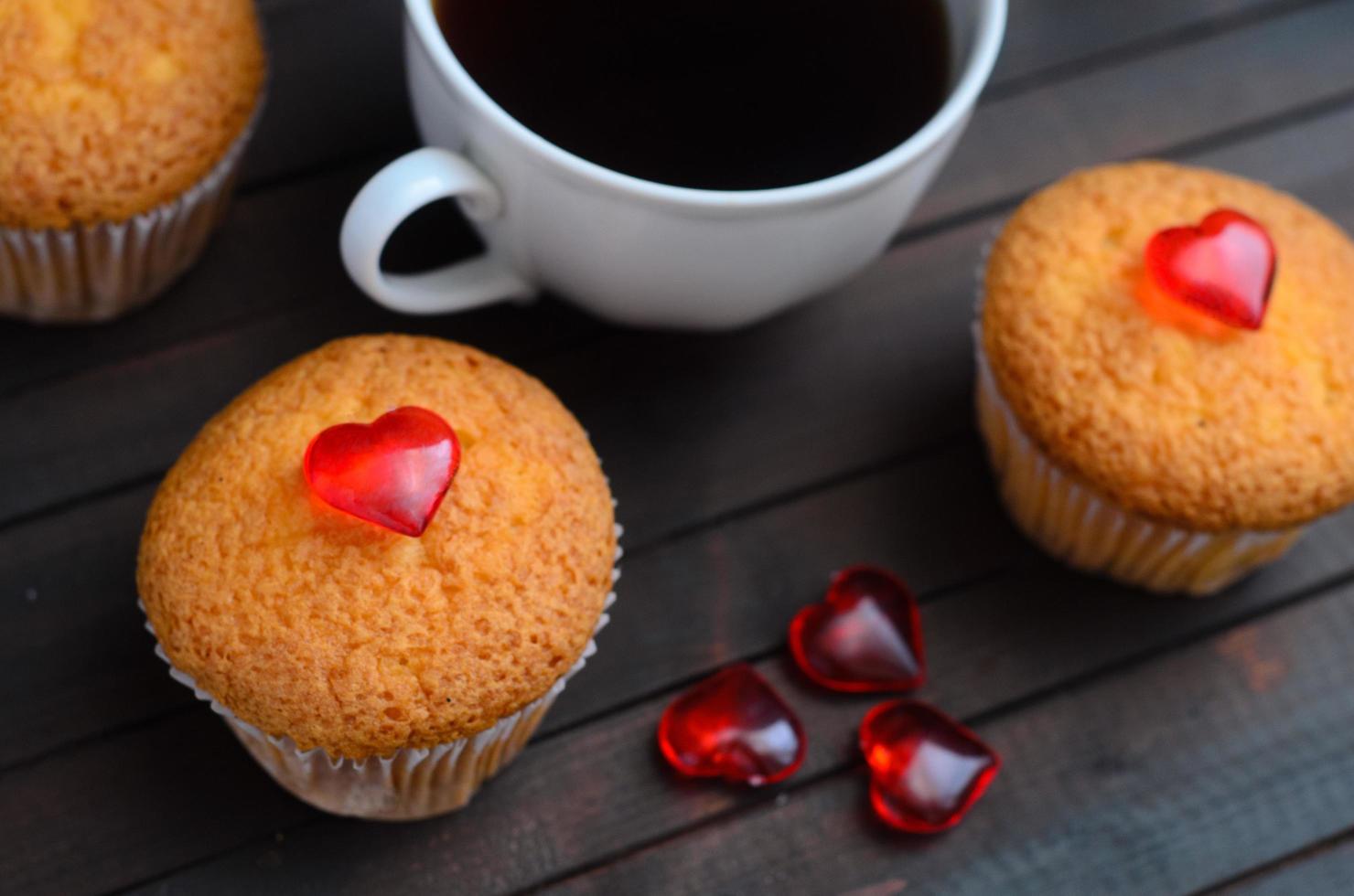 liebe cupcakes, kaffee und liebesherzen auf holzhintergrund. foto
