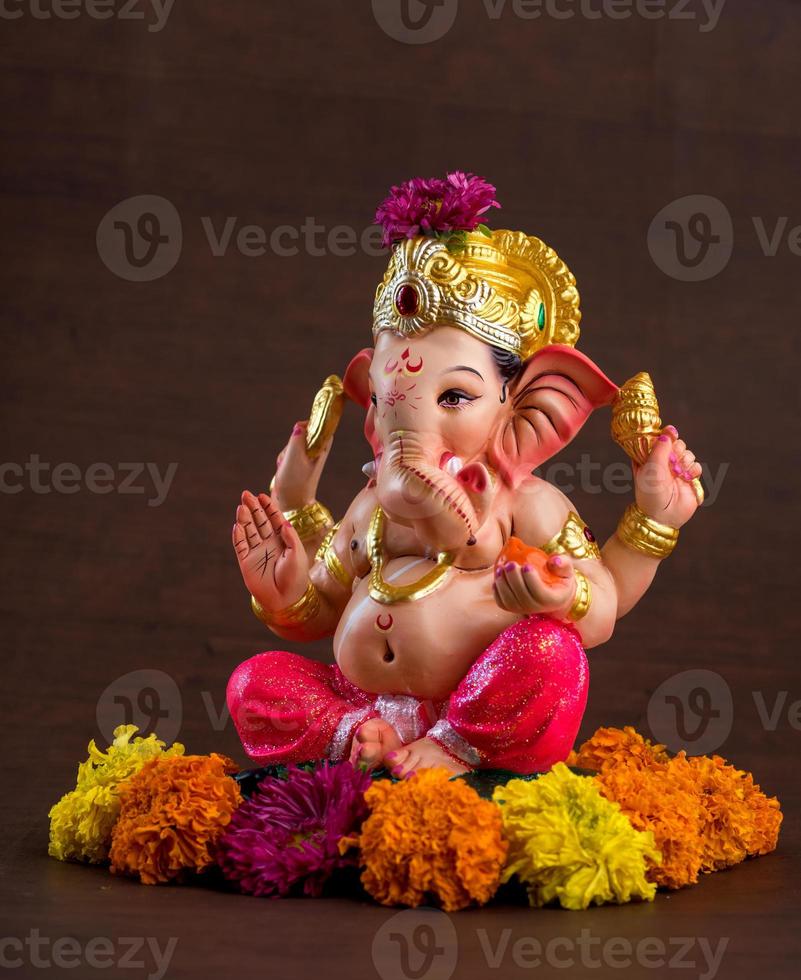 Hindu-Gott Ganesha. Ganesha-Idol auf dunklem Holzhintergrund. foto