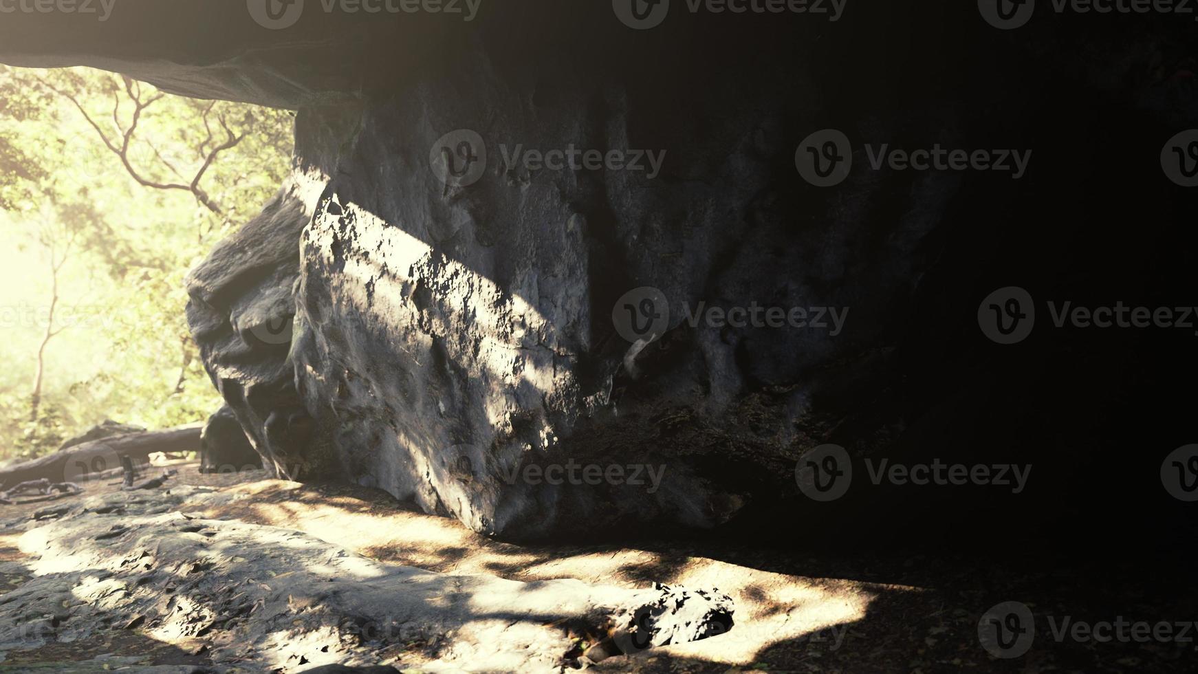 atemberaubende Landschaft heller Sonnenstrahlen, die in eine erhellende Höhle fallen foto