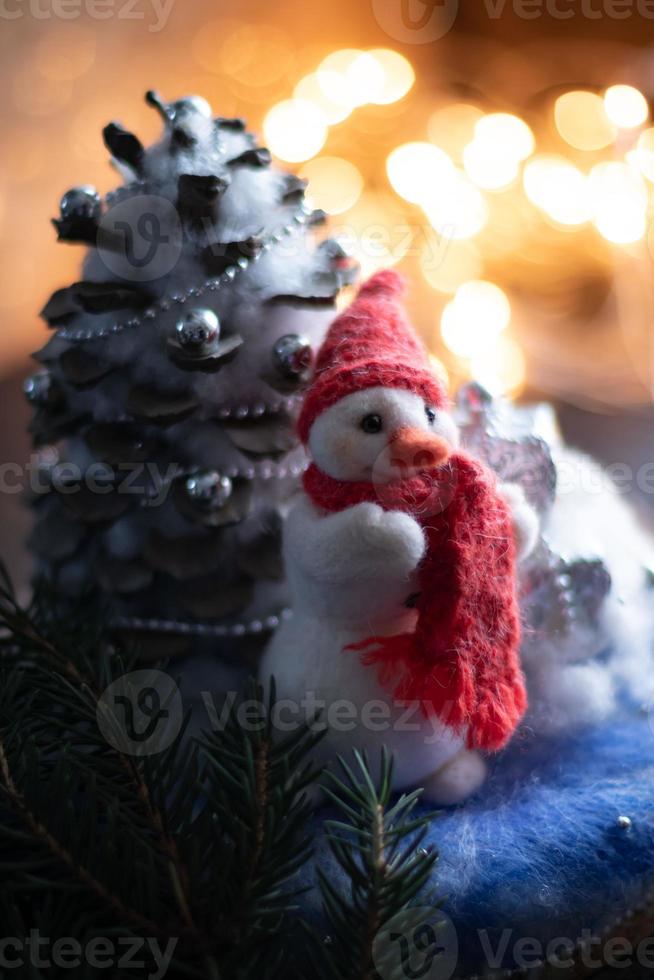 neujahrskomposition mit handgefertigtem schneemann mit rotem strickschal und mütze. foto