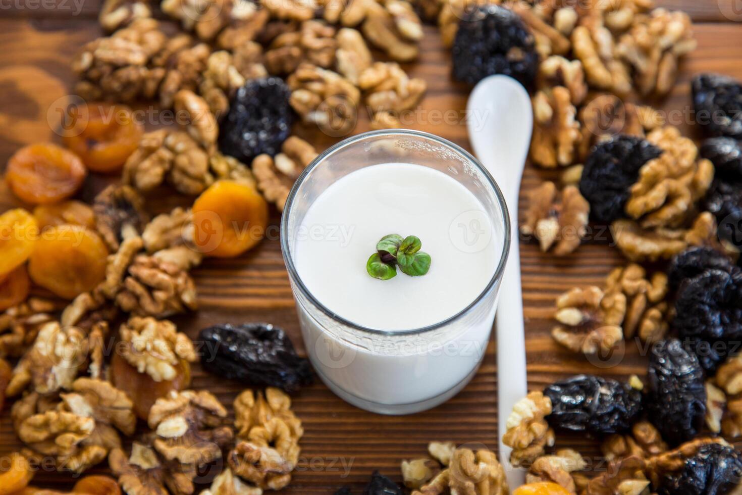 natürlich Joghurt mit Nüsse, getrocknet Aprikosen und Pflaumen auf ein hölzern Tabelle foto