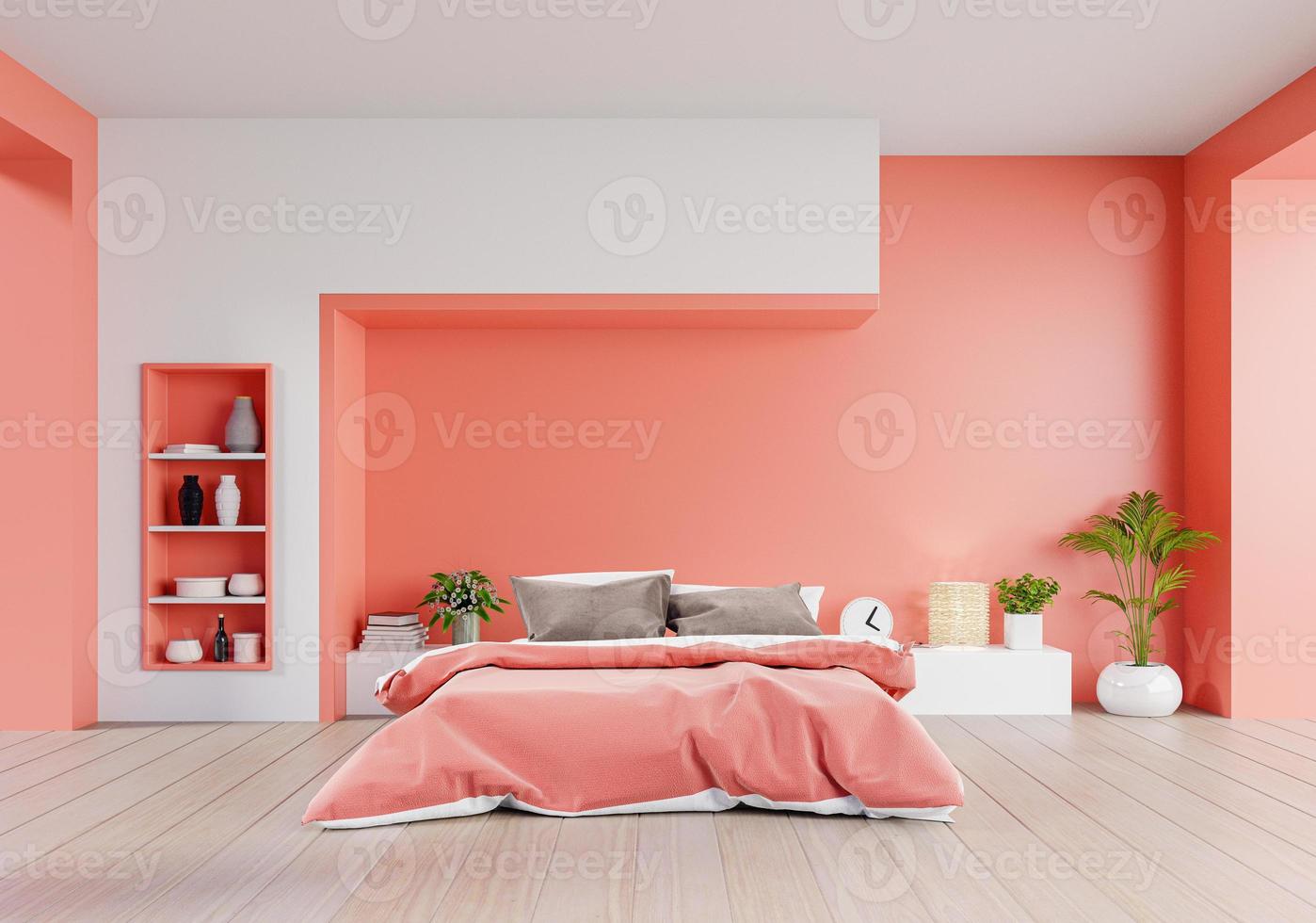 Wohnkorallenfarbenes Schlafzimmer eines Luxushauses mit Doppelbett und Regalen mit Wohnkorallenfarbenwand auf Holzboden. foto