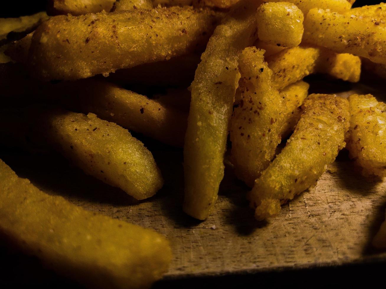 Nahaufnahme Foto von Pommes Frites auf einem Holzbrett.