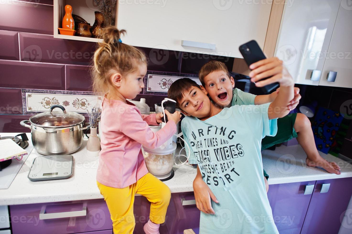 Kinder kochen in der Küche, glückliche Kindermomente. selfie am telefon machen. foto