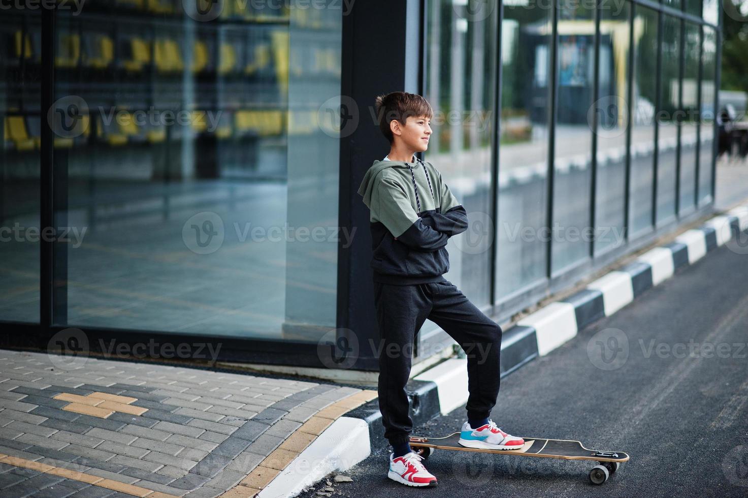 Teenager-Junge in einem Sportanzug mit Longboard. foto