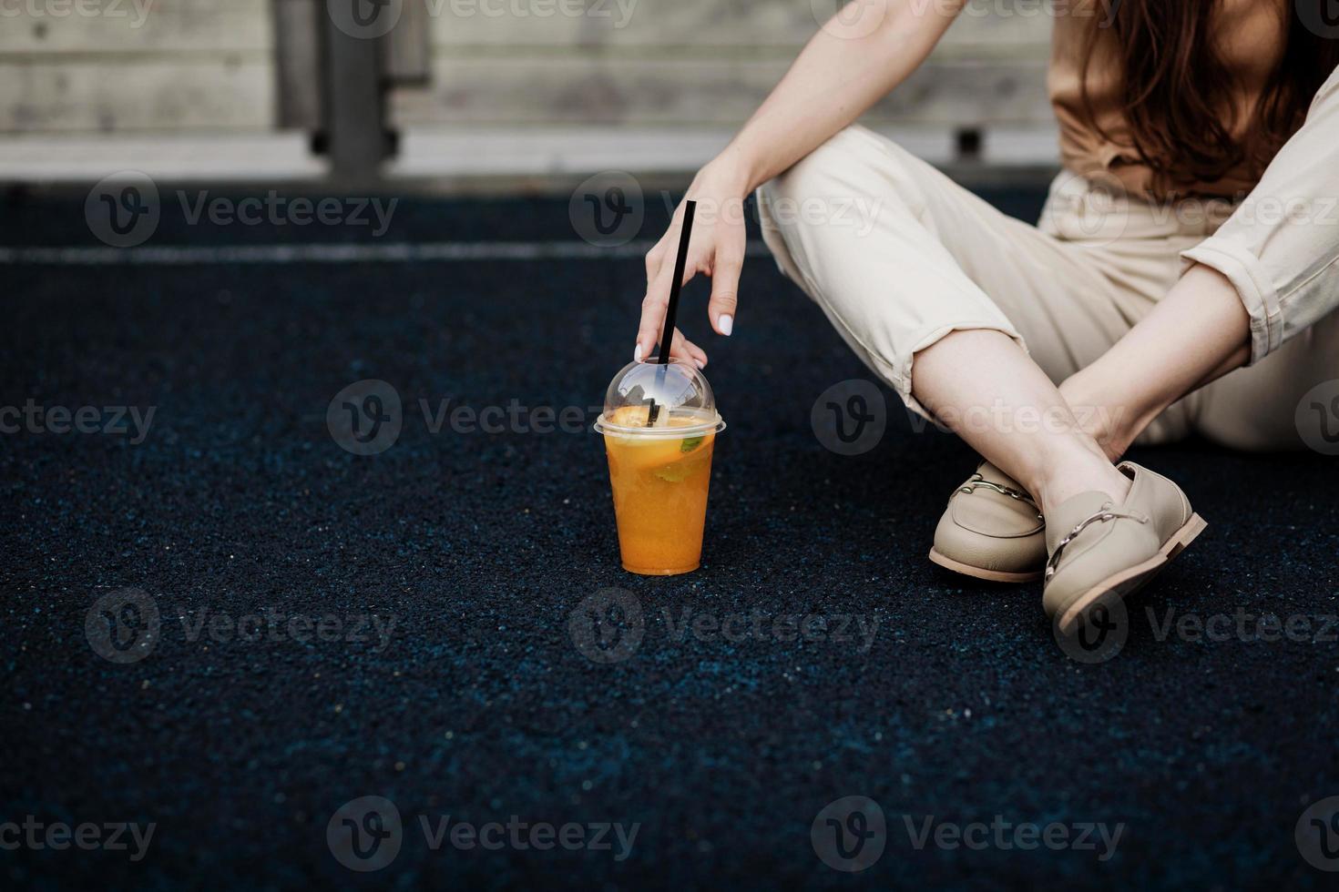 Frau mit Smoothie trinkt Plastikbecher foto