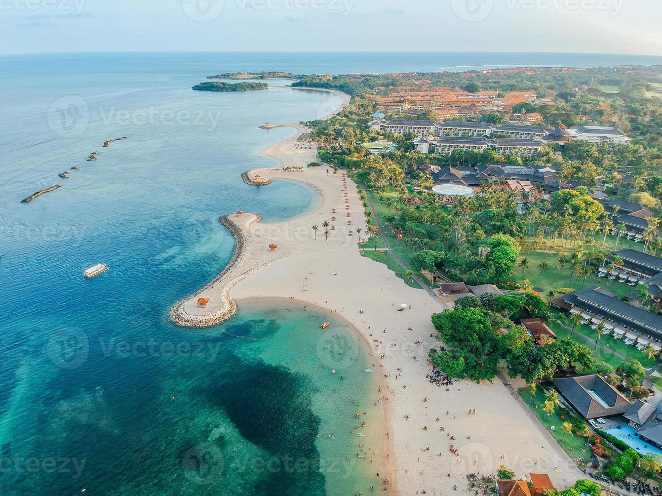 luftdrohnenansicht des urlaubs in sanur beach, bali, indonesien mit ozean, booten, strand, villen und menschen. foto