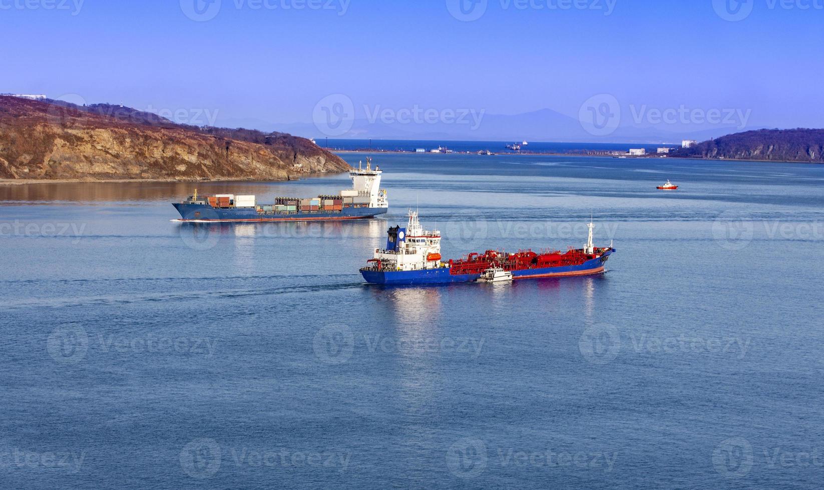 großes Containerschiff und Kühlschiff auf blauem Meer foto