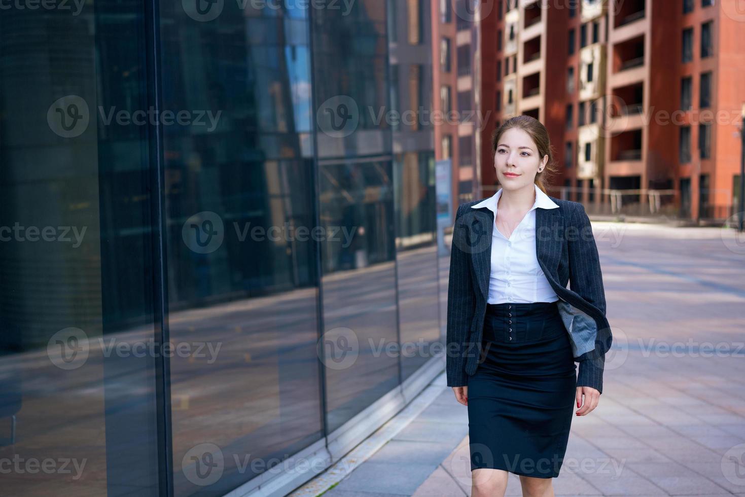 erfolgreiche junge Frau auf dem Hintergrund eines Bürogebäudes foto