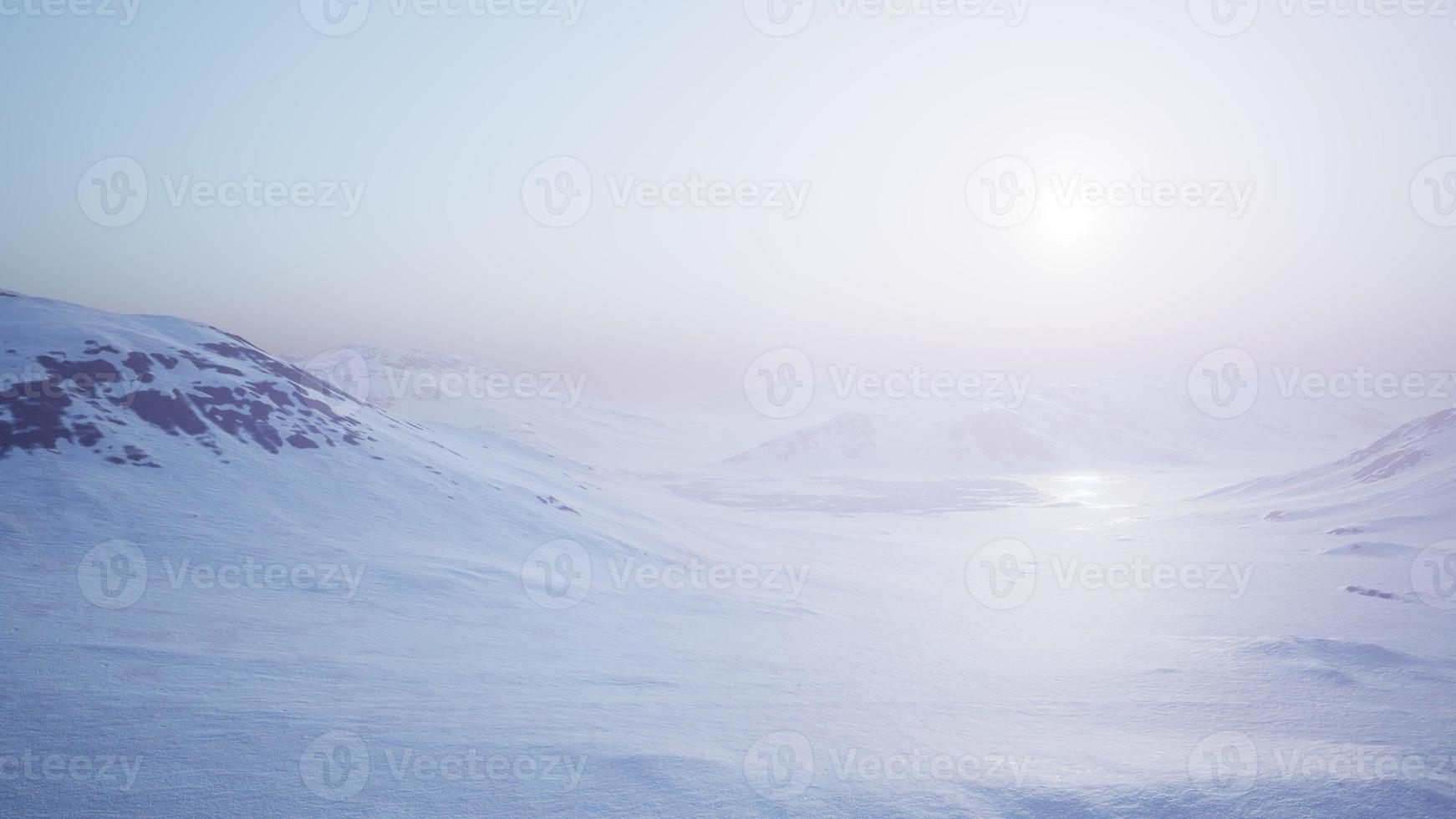 Luftlandschaft von schneebedeckten Bergen und eisigen Küsten in der Antarktis foto