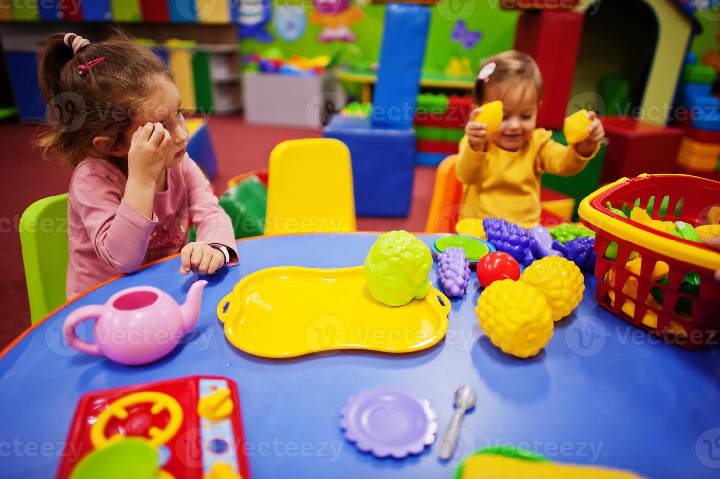 süße Schwestern spielen im Indoor-Spielzentrum. Kindergarten oder Vorschulspielzimmer. in der Kinderküche. foto