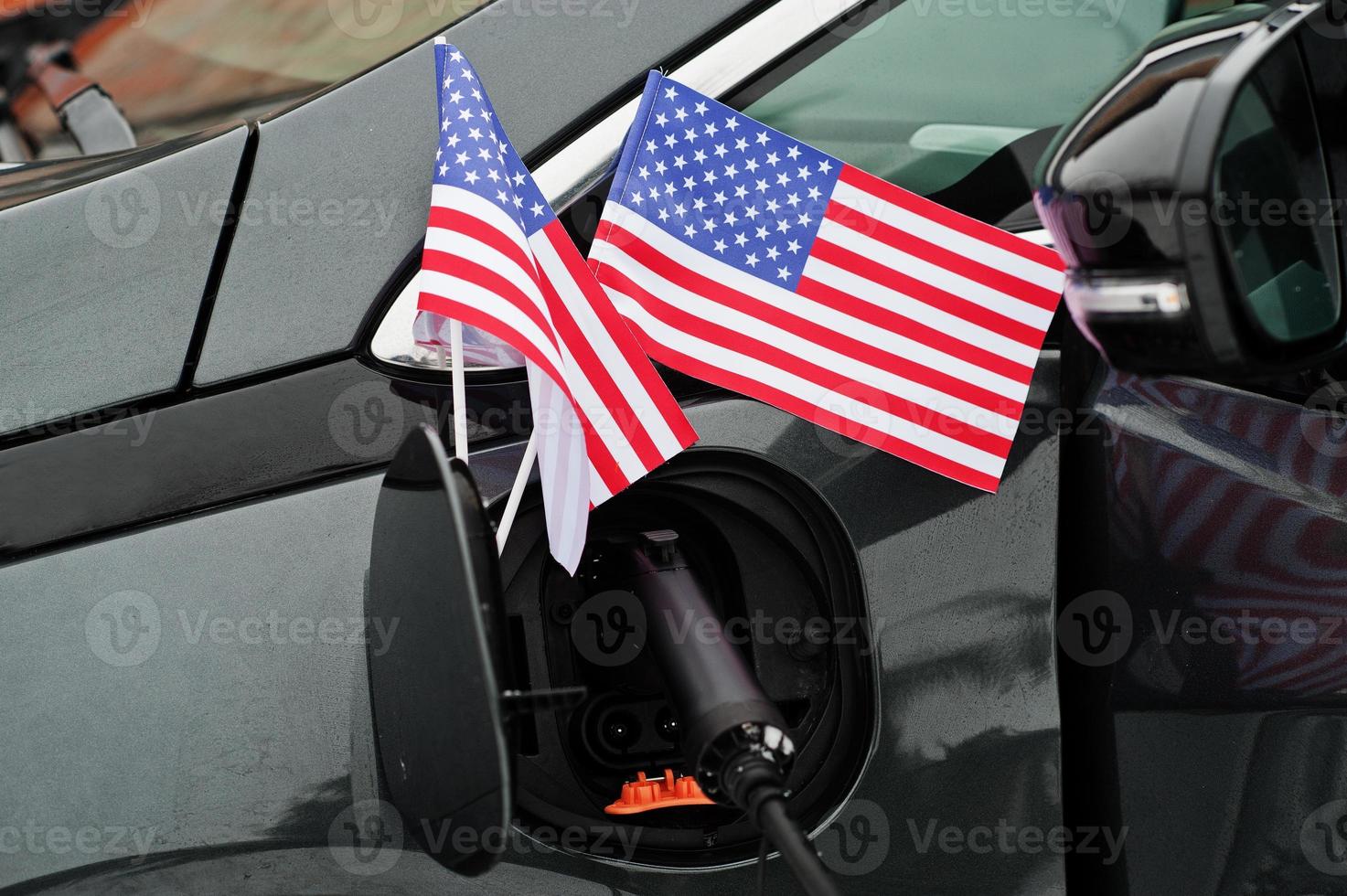 Ökologisches autokonzept der usa-flagge. Stromversorger einstecken, modernes Auto aufladen. foto