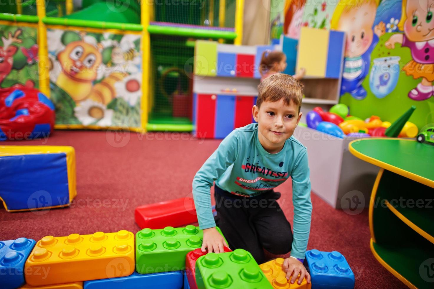 süßer Junge, der im Indoor-Spielzentrum spielt. baut mit Konstruktorsteinen. foto