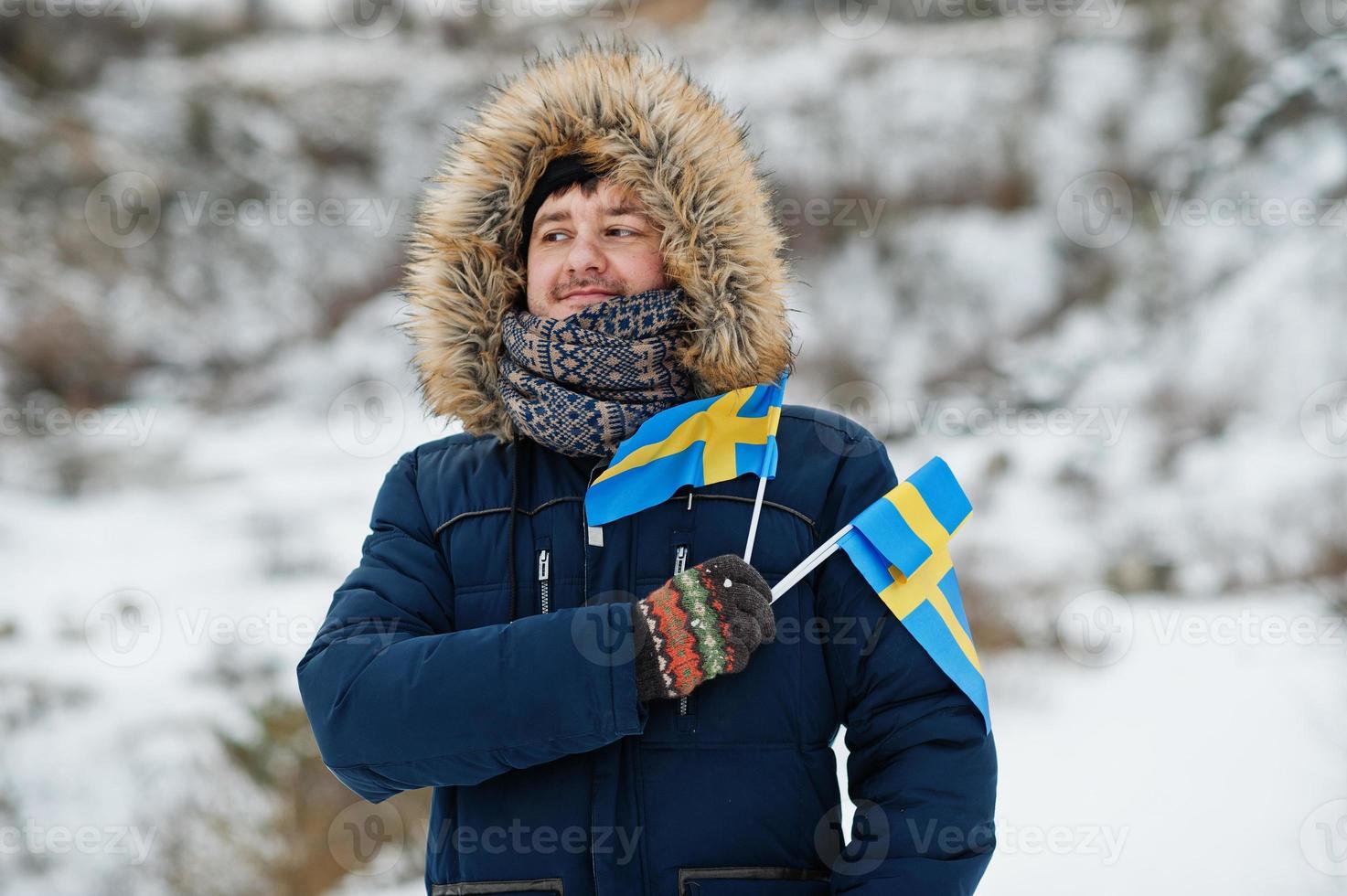 skandinavischer mann mit schwedenflagge in der schwedischen winterlandschaft. foto