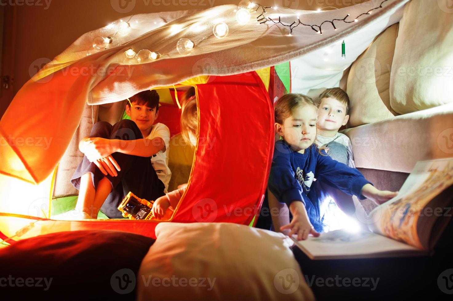 Spielende Kinder im Zelt nachts zu Hause. Hygge-Stimmung. foto