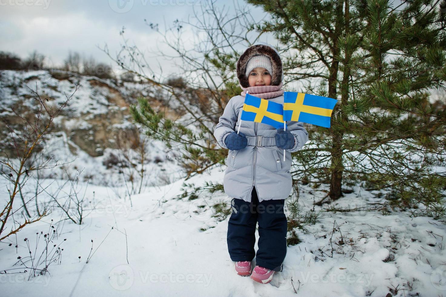 skandinavisches Mädchen mit Schweden-Flagge in der schwedischen Winterlandschaft. foto
