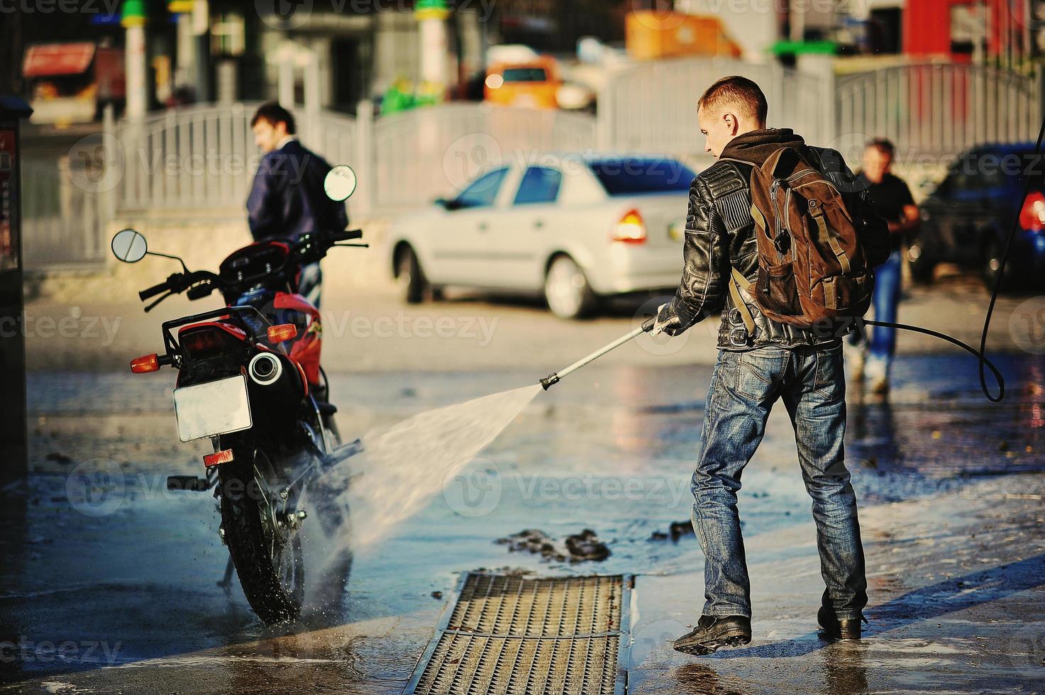 Fahrradfahrer, der sein Motorrad wäscht foto