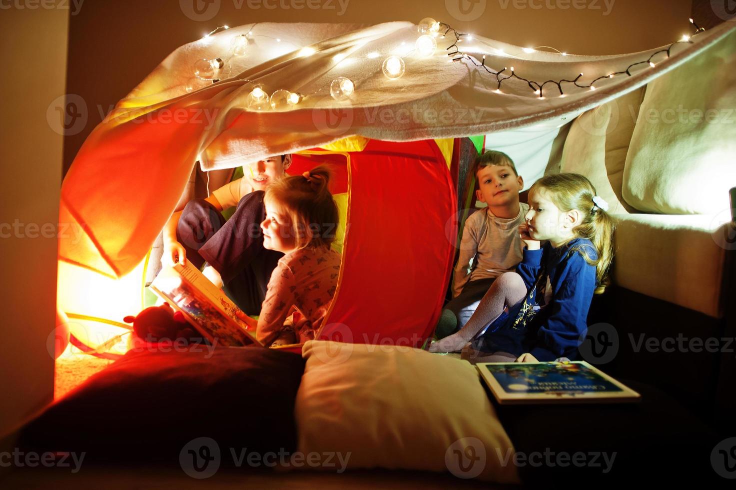 Spielende Kinder im Zelt nachts zu Hause. Hygge-Stimmung. foto
