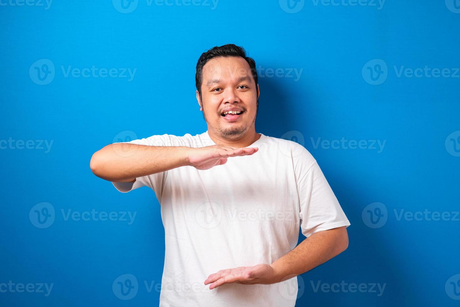 asiatischer junger mann im lässigen hemd, das nach vorne zeigt, blick in die kamera, macht die wahl, die sie vor rotem hintergrund gestikulieren foto