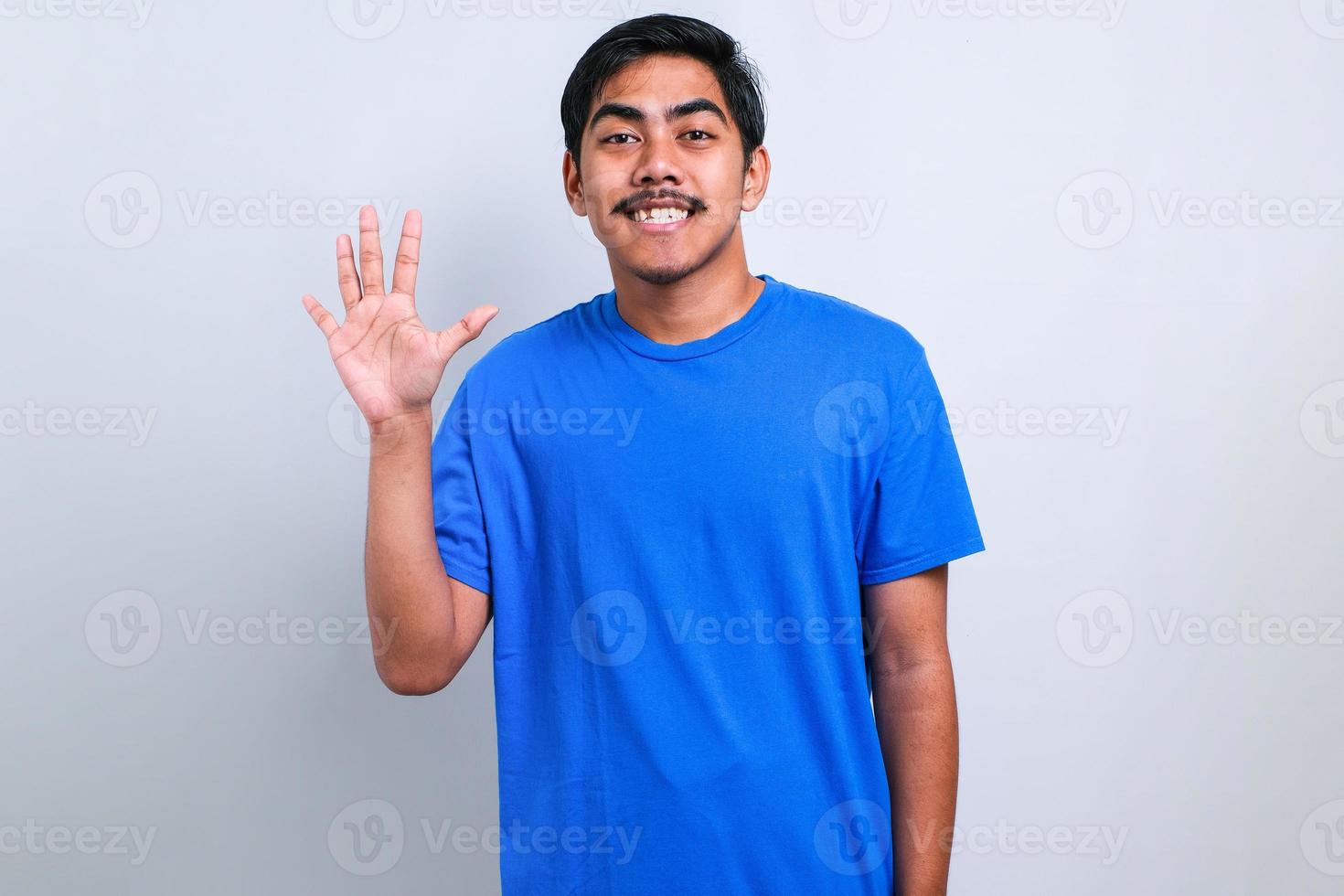 asiatischer mann, der mit den fingern verschiedene nummern zeigt und nach oben zeigt foto