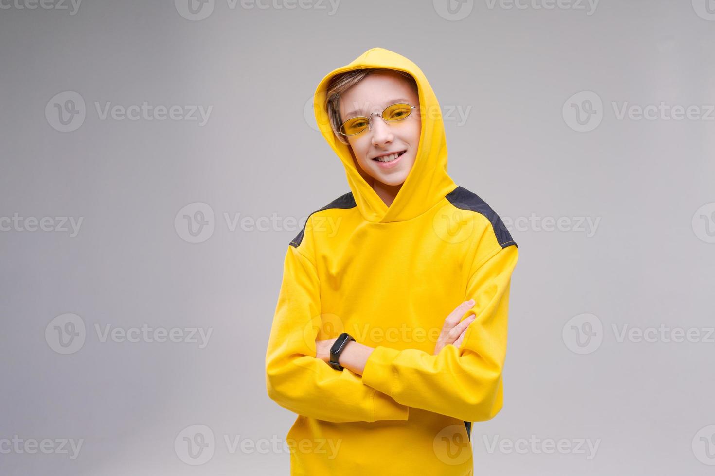 lustiger neugieriger junger mann in lässigem gelbem sweatshirt, kapuze und gelb foto