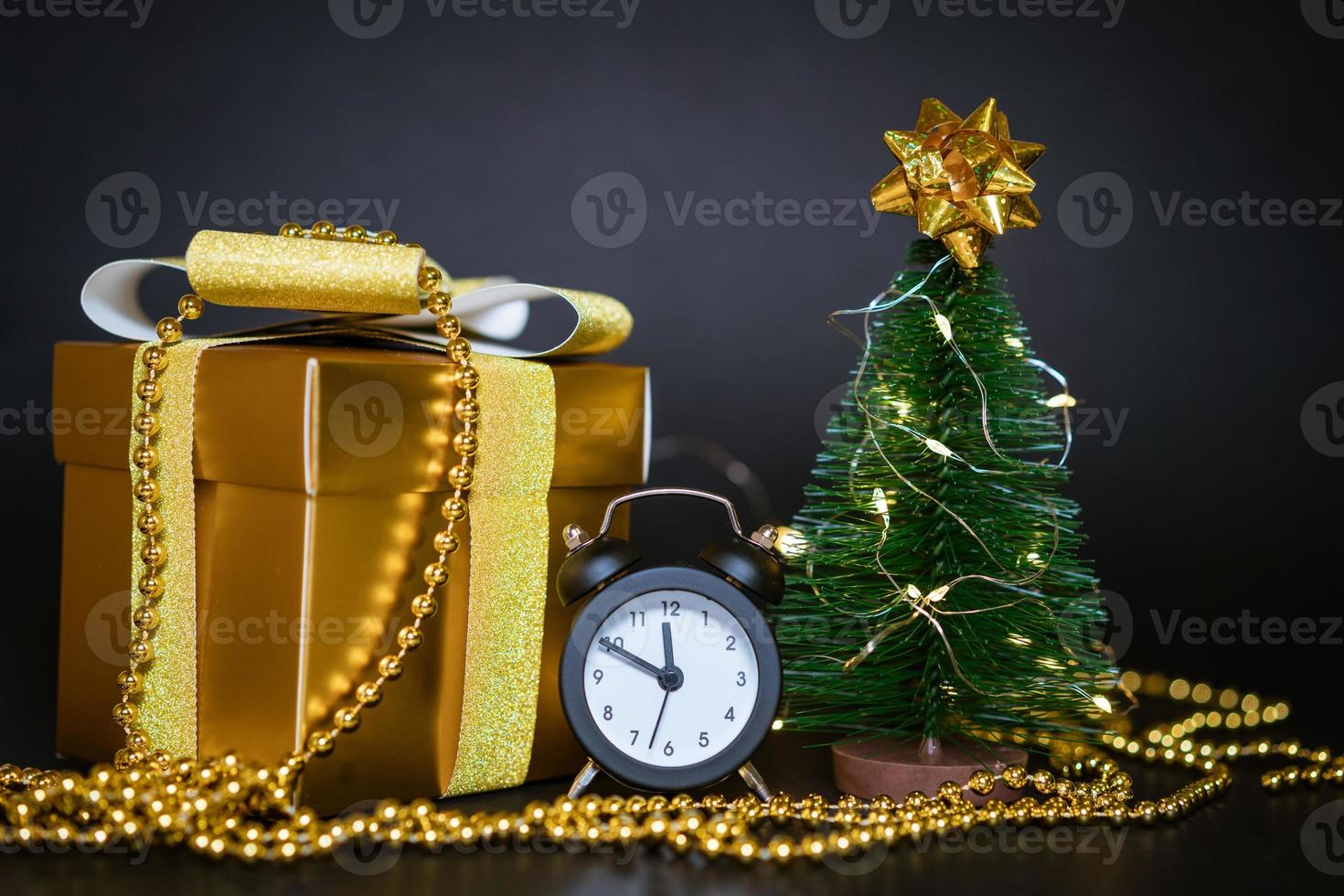 Geschenkbox mit kleinem Weihnachtsbaum auf schwarzem Hintergrund foto