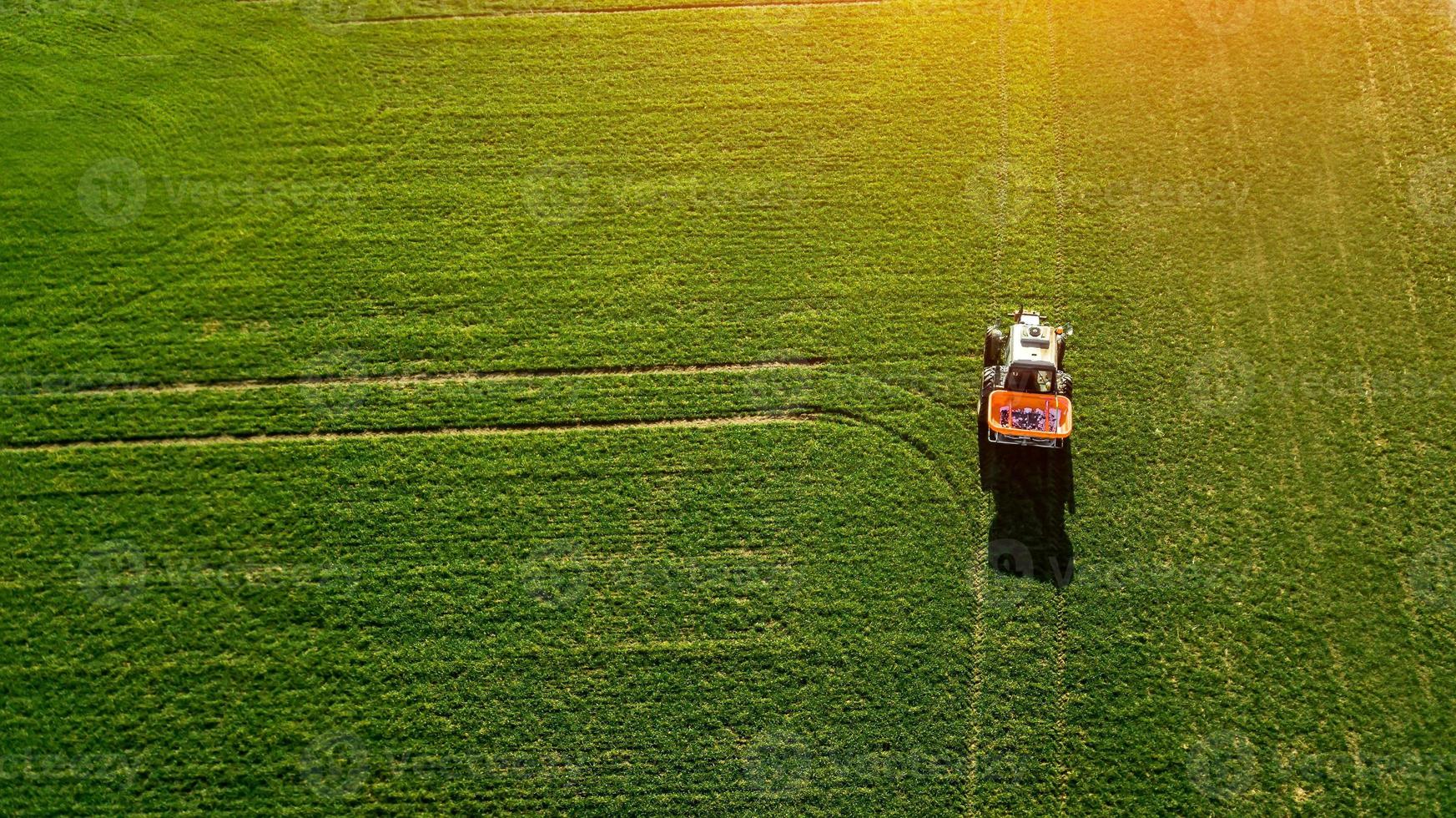 Traktor macht Dünger auf dem Feld. Ansicht von oben foto