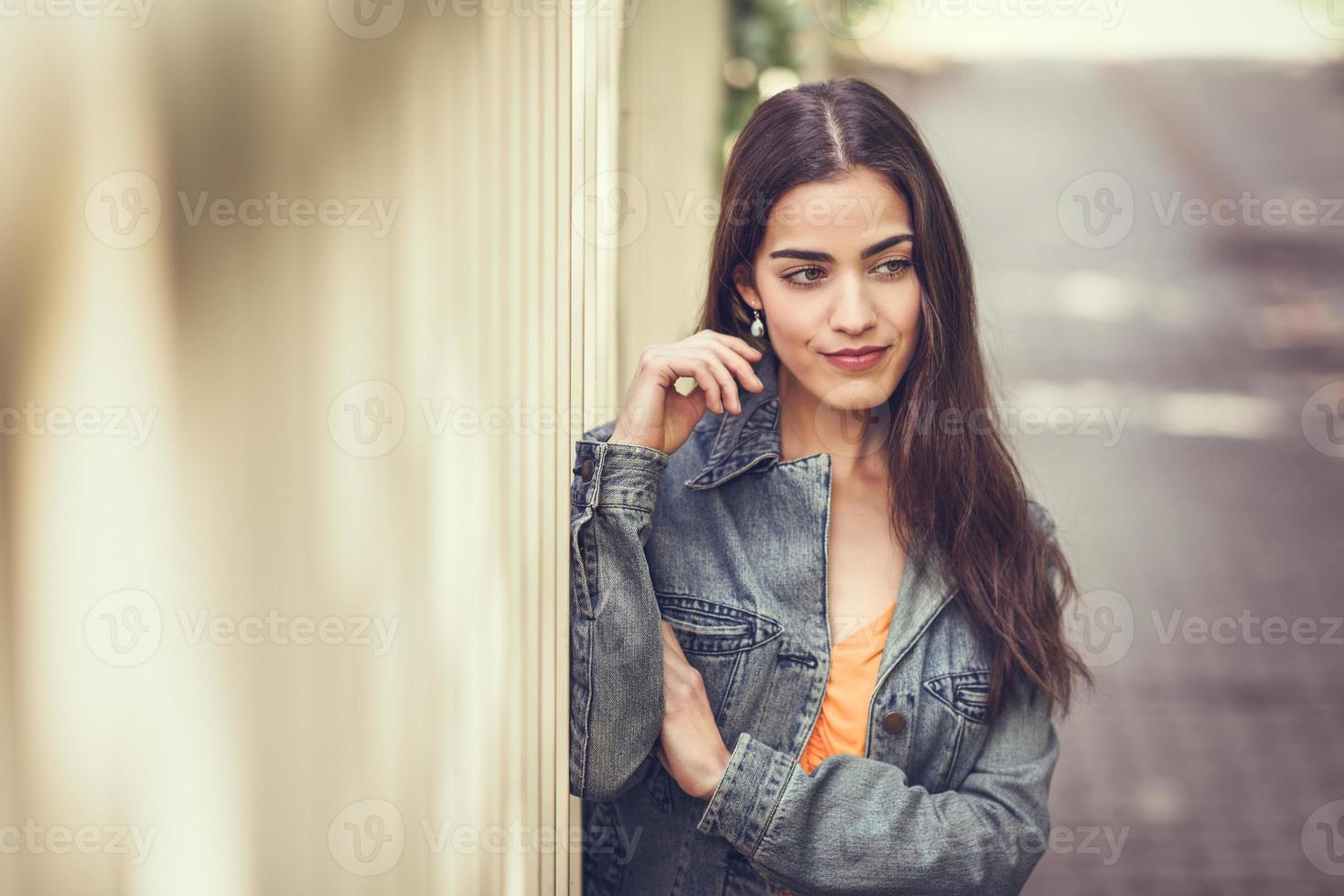 Frau mit schönem Haar, die lässige Kleidung im städtischen Hintergrund trägt. foto