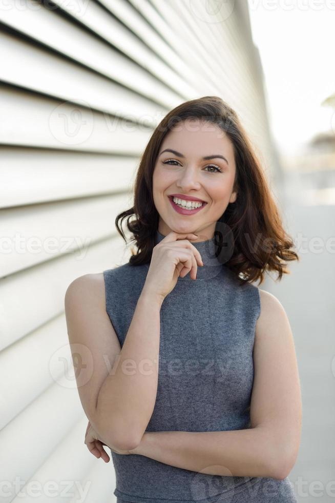 junge Frau, die im städtischen Hintergrund lächelt foto